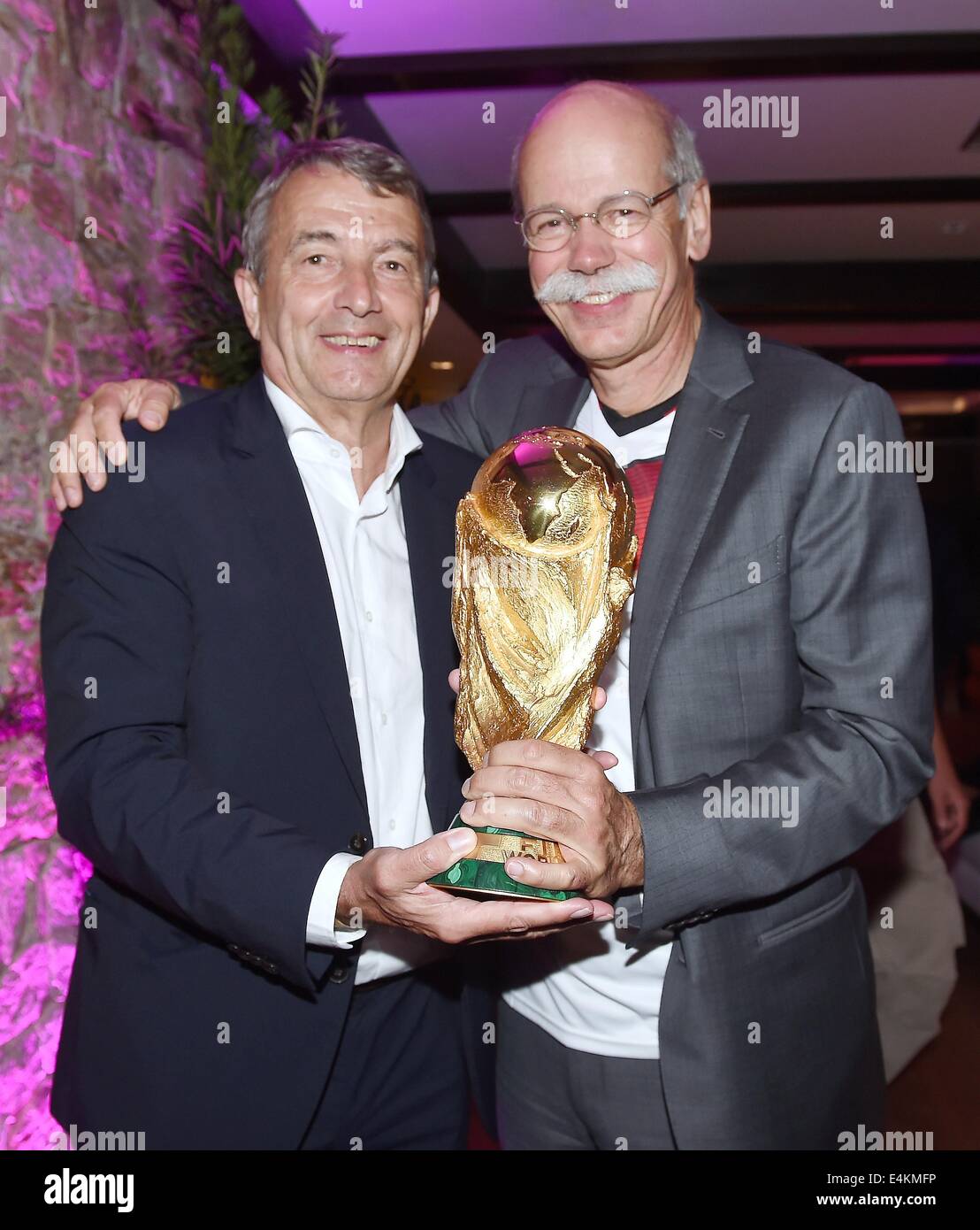 Handout: Rio de Janeiro, Brazil. 14th July, 2014. The handout photo released by Ges/Markus Gilliar on 14 July 2014 shows Dieter Zetsche (R), Chairman of Damiler AG congratulating DFB President Wolfgang Niersbach on Germany's victory over Argentina in the Soccer World Cup with the trophy at Hotel Sheraton in Rio De Janeiro, Brazil on 13 July 2014. Germany won the World Cup 1-0 after defeating Argentina. Credit:  dpa picture alliance/Alamy Live News Stock Photo