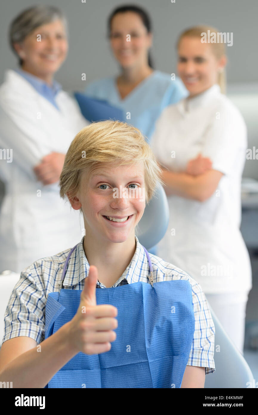 Boy patient professional dentist team thumbup at dental surgery Stock
