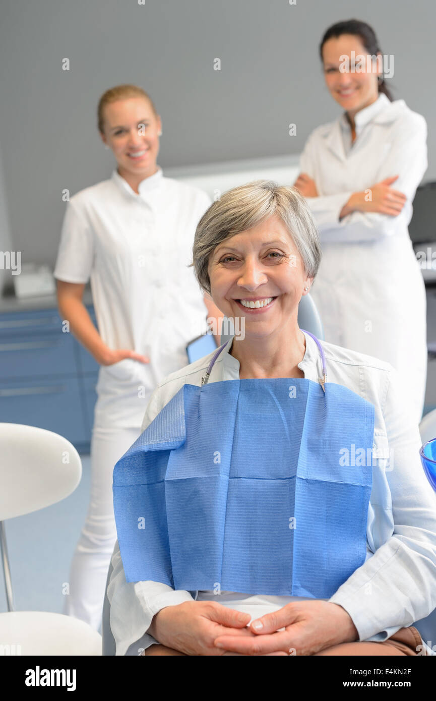Senior woman patient with professional dentist team at dental surgery Stock Photo