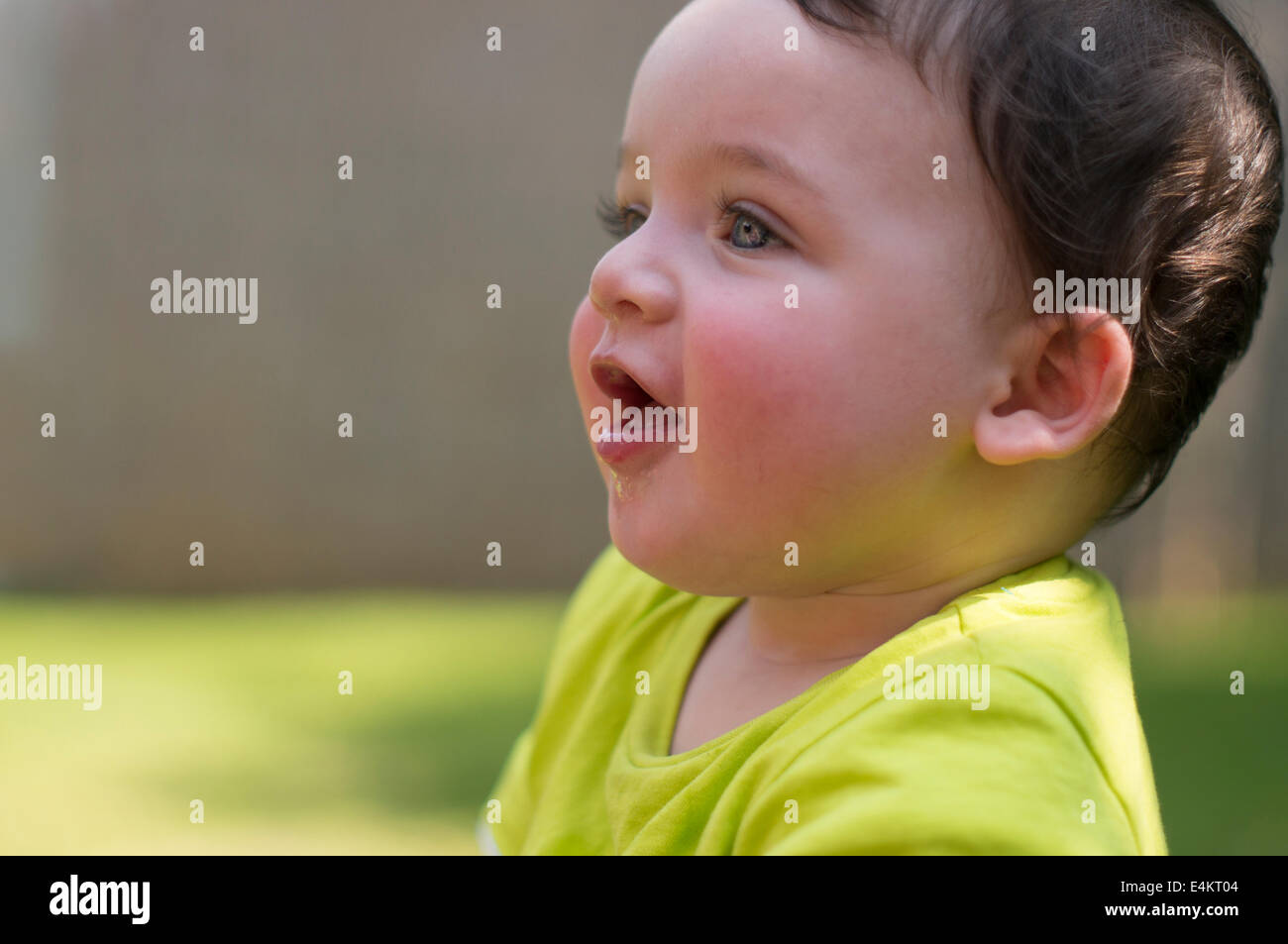 Smiling baby in green t-shirt. Stock Photo