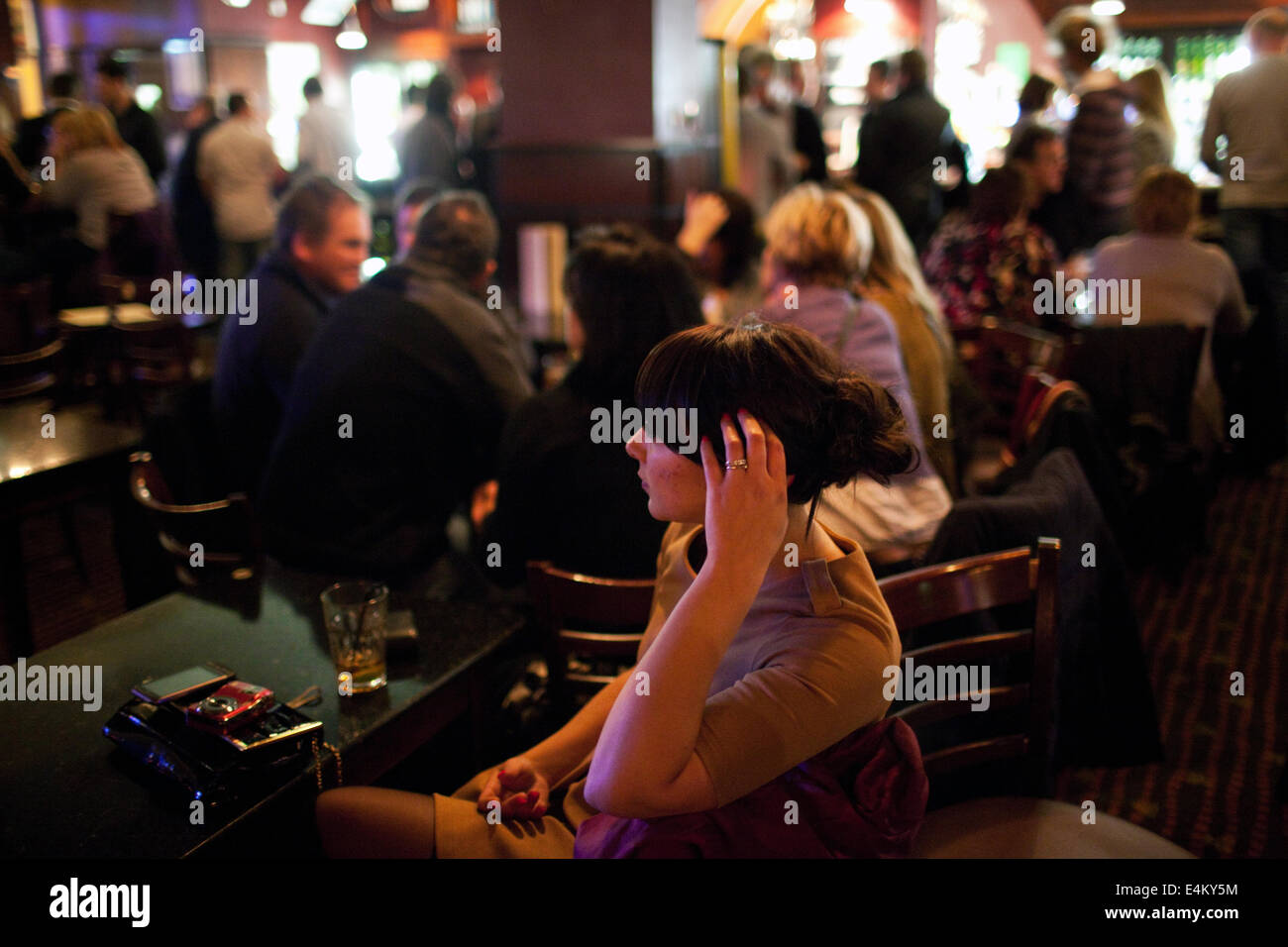 A young woman in a pub on a weekend night in Cardiff, Wales, UK Stock Photo