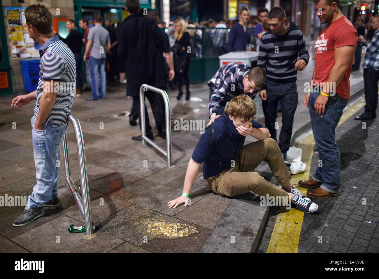 A young man sick in public (after vomiting) on a weekend night out in Cardiff, Wales, UK Stock Photo