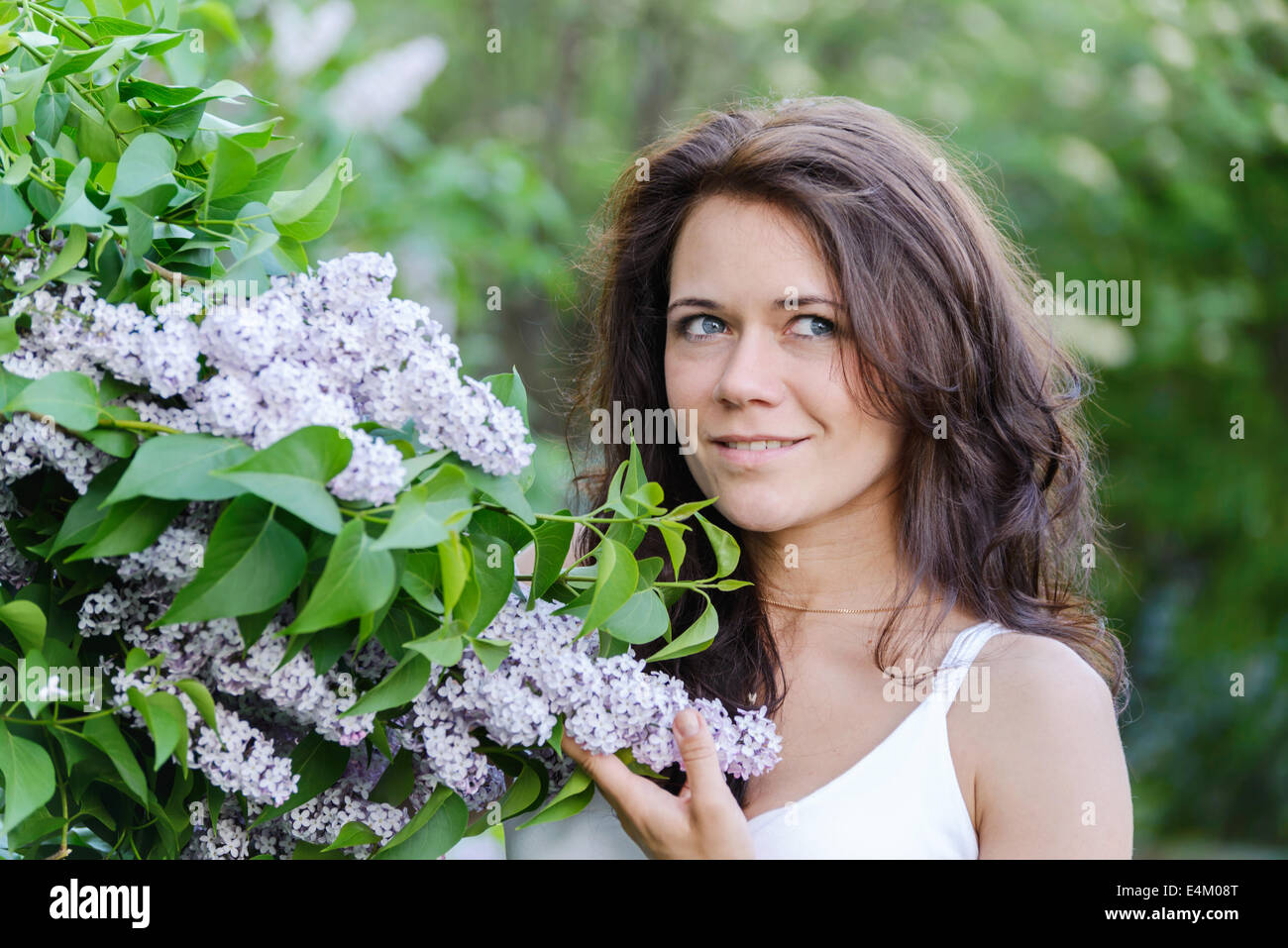 Girl near blossoming lilac Stock Photo
