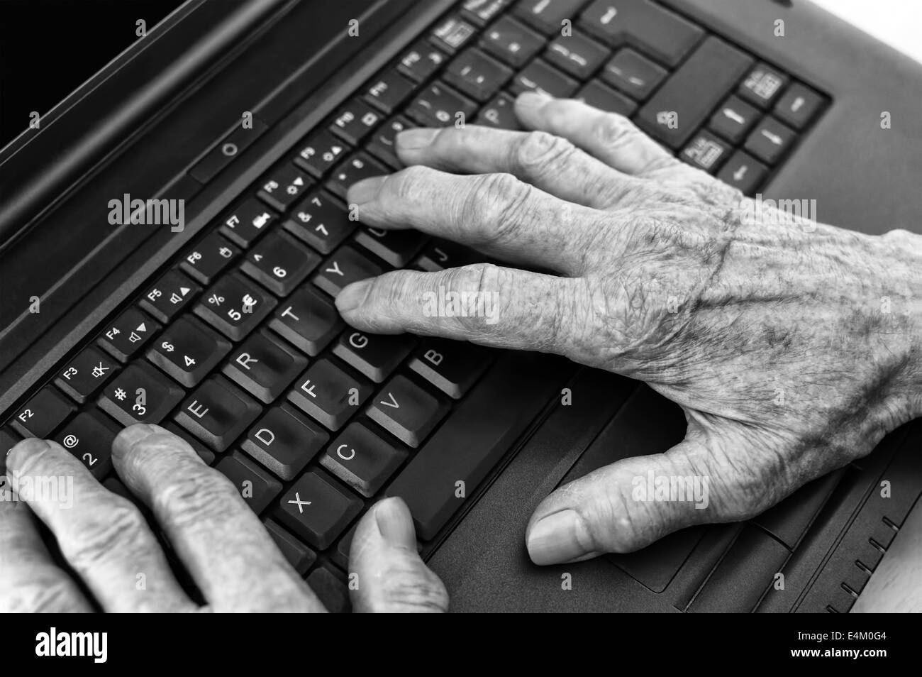Closeup on elderly hands on keyboard of laptop. Stock Photo