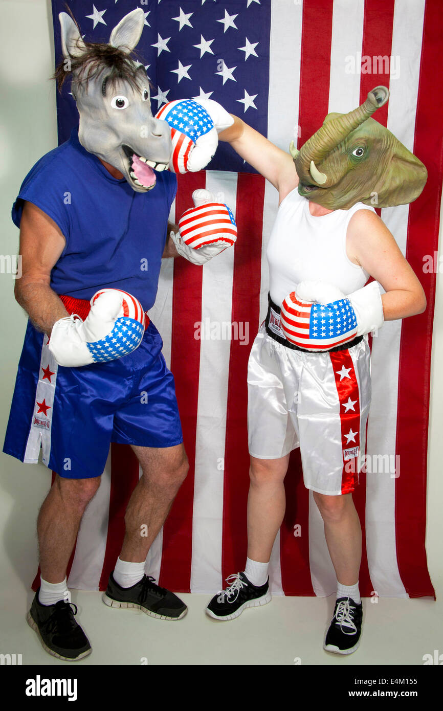 Republican Elephant landing a punch on a Democrat Donkey standing in front of an American flag Stock Photo