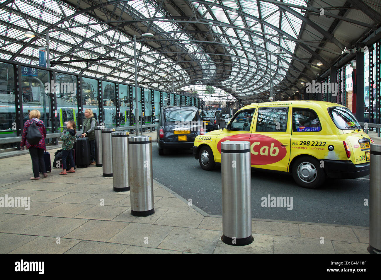 Taxis in Lime Street, Liverpool, Merseyside, UK. Taxi rank, TX4,  taxicab, hackney carriage, cab at busy Train Station with arrivals for Open Golf.  Increased passenger traffic has been reported as visitors to Liverpool and the Wirral arrrive to make connections for the Passengers and taxi cabs at Open Golf at Hoylake this week.  Hoylake station is on the Merseytravel 'Wirral Line' in the direction of West Kirby, which can be accessed from the concourse at Liverpool Lime Street railway station.   Merseyrail is the a preferred means for visitors to arrive at the Championship. Stock Photo