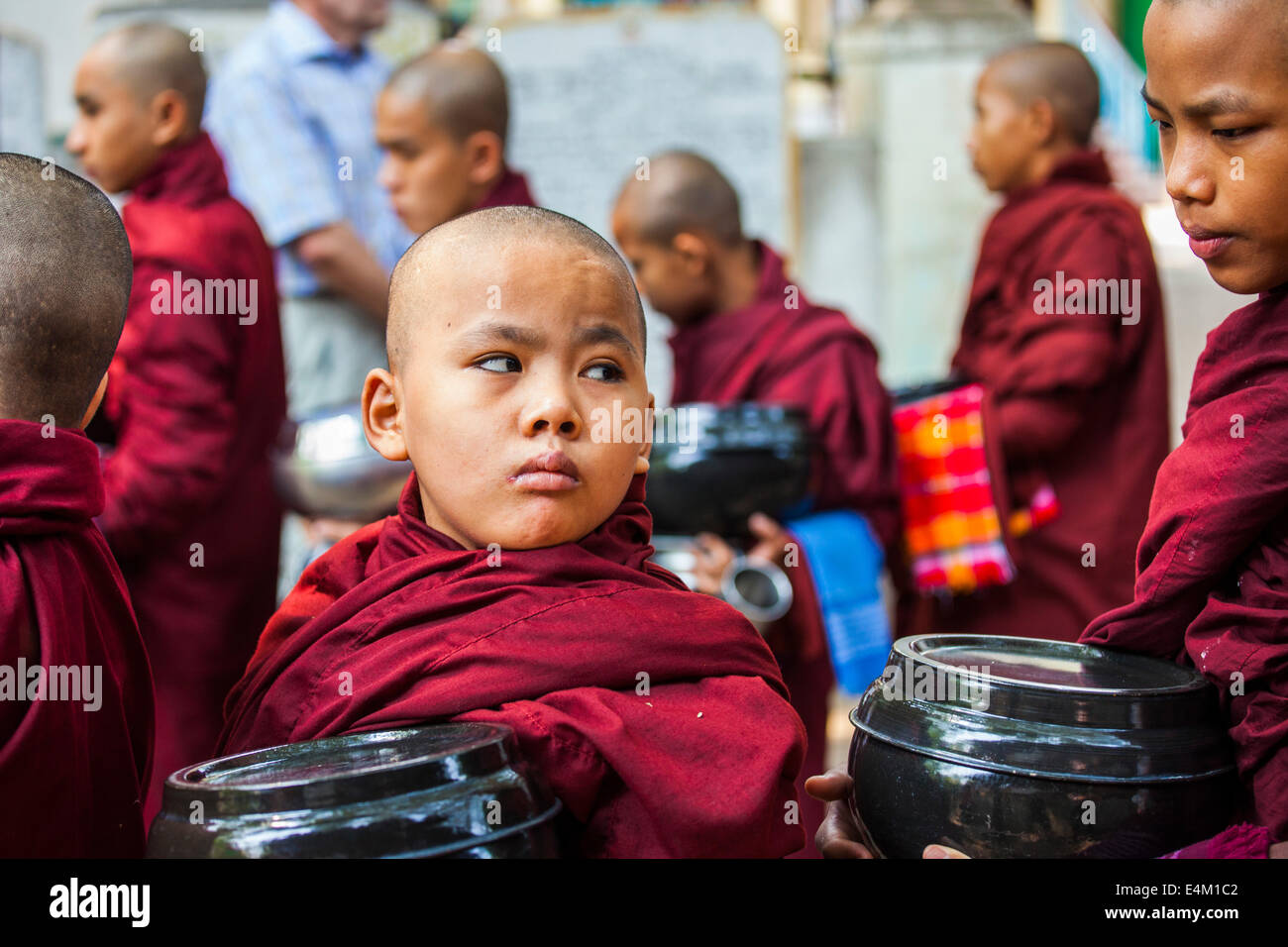 Young Buddhist monks wait in line for food during an Alms Ceremony at