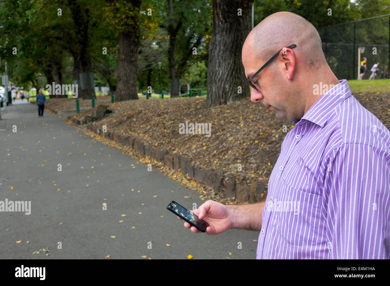 Melbourne Australia,Victoria Flagstaff Gardens,city park,adult adults man men male,smartphone smartphones mobile cell smart phone phones,checking look Stock Photo