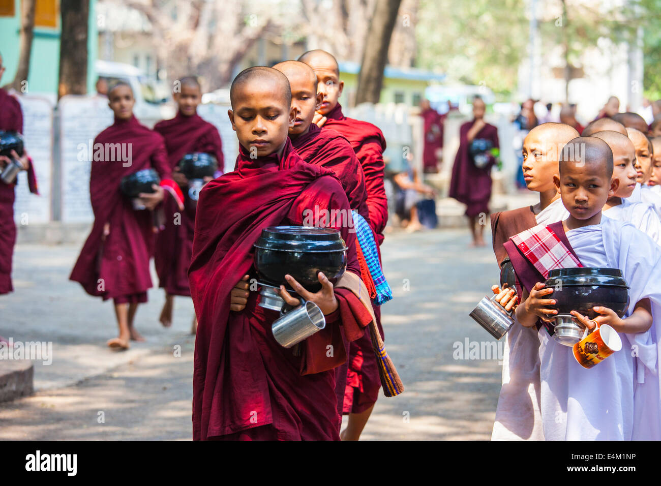 Buddhist monks and nuns wait for food during an Alms Ceremony at the Maha Aung Mye Bonzan Monastery in Mandalay, Myanmar. Stock Photo