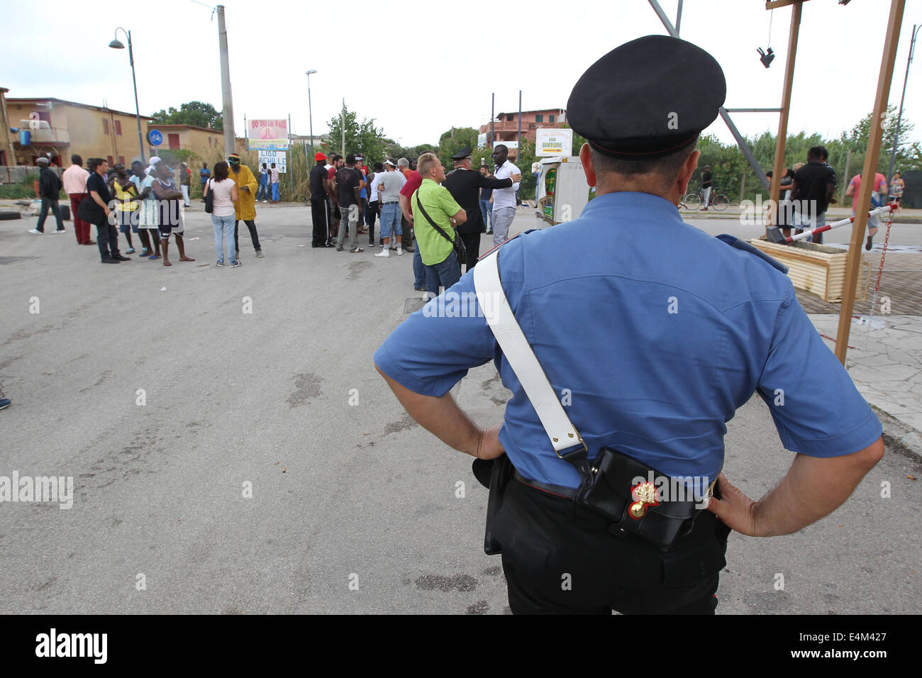 Castel Volturno, Italia. 14th July, 2014. Revolt immigrants: Domitiana state road, a major artery between the regions of Campania and Lazio blocked due to a revolt before the immigrants and then the residents of the resort town of Pescopagano because of clashes the night before for a shootout between immigrants and residents. In this photo: policemen guarding the immigrants who are blocking for protestaun crossing within the country-  Credit:  Marco Cantile/NurPhoto/ZUMA Wire/Alamy Live News Stock Photo