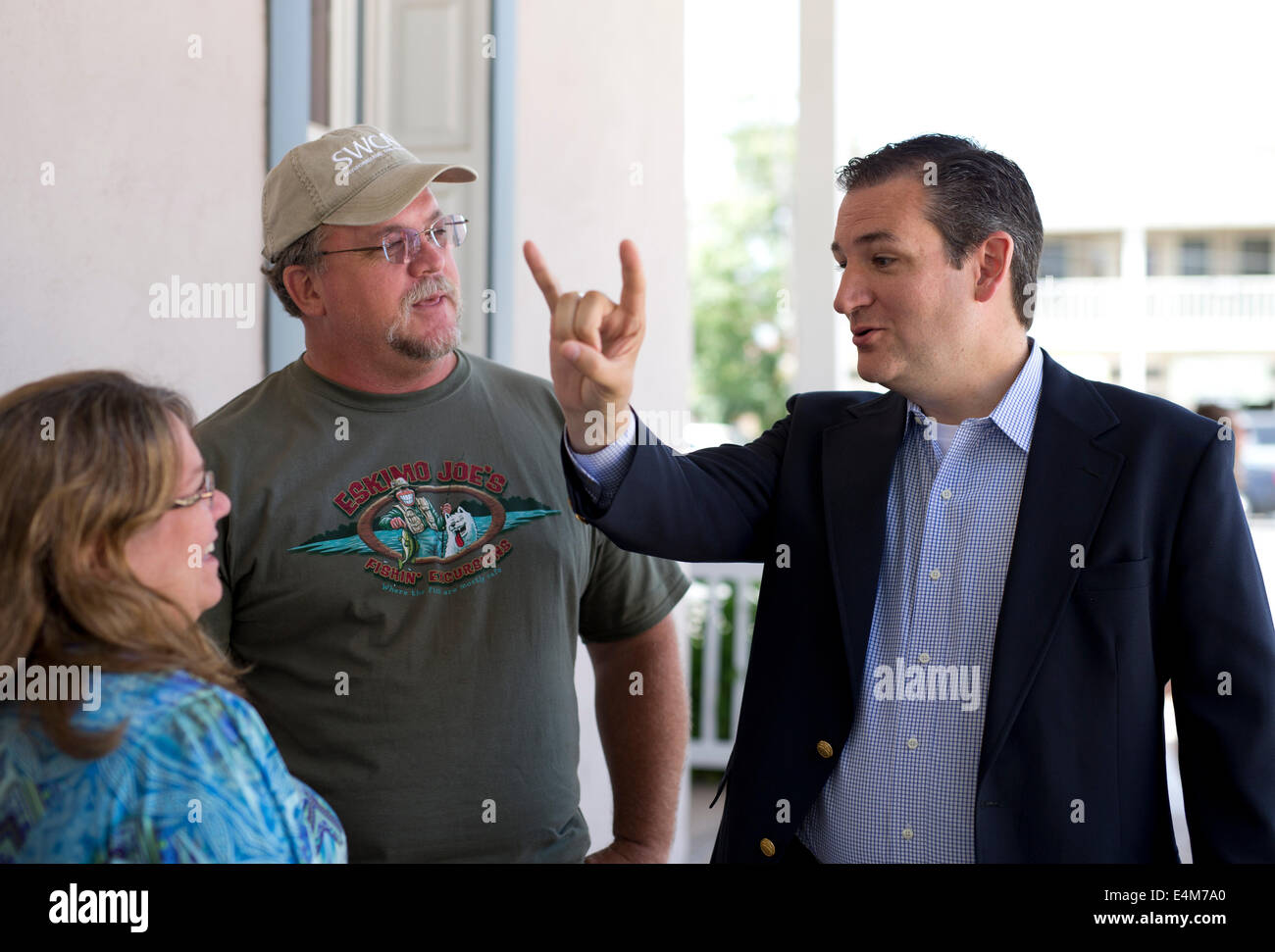 Republican U.S. Senator Ted Cruz flashes a 'Hook-em 'Horns' sign as he visits with constituents in downtown Fredericksburg Texas Stock Photo