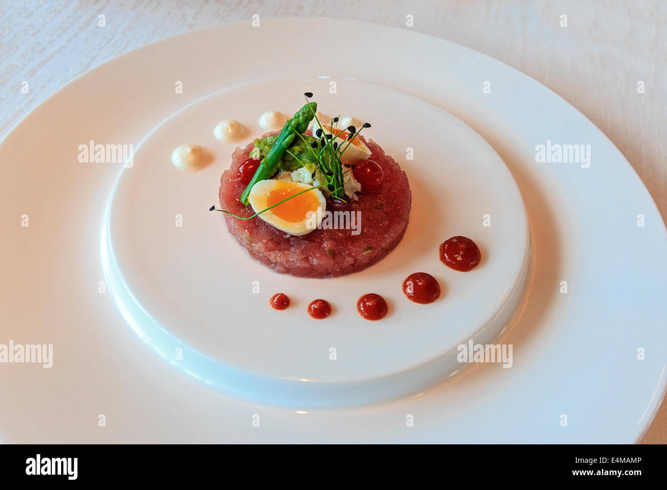 Tuna tartare with quail egg, asparagus and bean sprouts appetizer at fancy hotel restaurant in Dubai Stock Photo