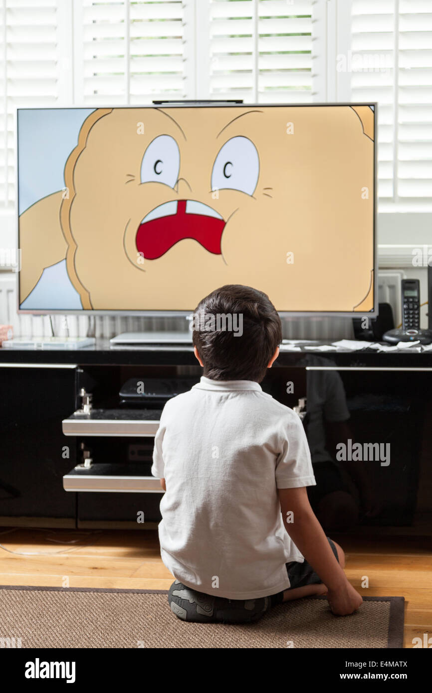 Child watches cartoon on TV at home Stock Photo