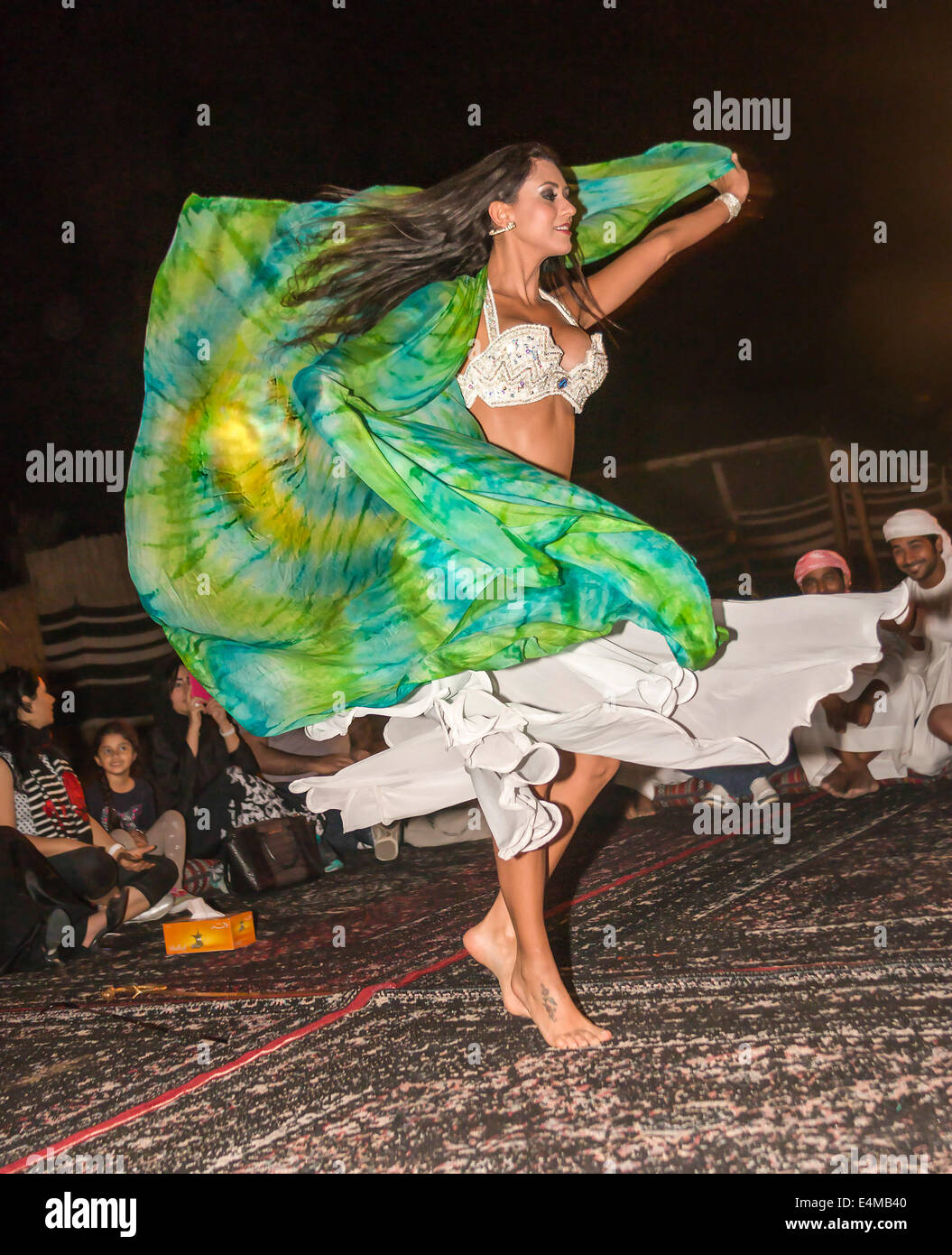 Belly dancer twirls for guests at Bedouin desert safari camp outside Dubai, UAE Stock Photo