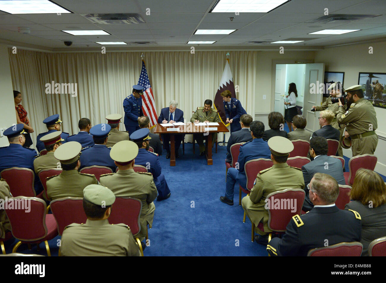 Washington, DC, USA. 14th July, 2014. U.S. Defense Secretary Chuck Hagel (L) and Qatar's Minister of State for Defense Affairs Hamad bin Ali al-Attiyah sign documents at the Pentagon, Washington, DC, capital of the United States, July 14, 2014. U.S. and Qatar have signed an arms deal on Qatar's purchase of U.S. Patriot defense systems and Apache helicopters to the tune of 11 billion dollars, the U.S. Defense Department said in a statement on Monday. Credit:  Yin Bogu/Xinhua/Alamy Live News Stock Photo