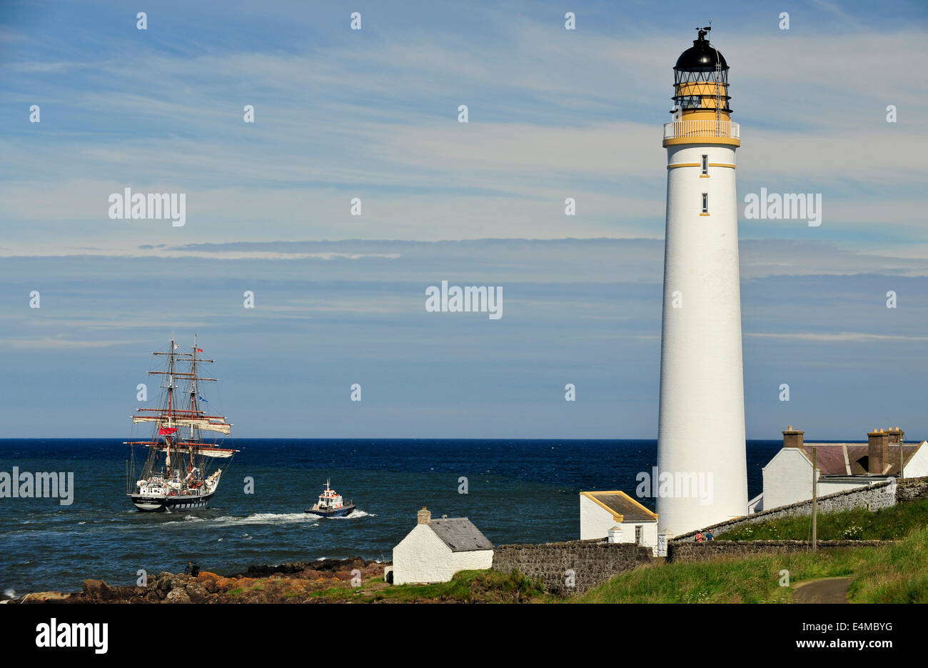 The Stavros S Niarchos a British brig-rigged tall ship is escorted past Scurdie Ness Lighthouse, Montrose, Angus, Scotland. Stock Photo
