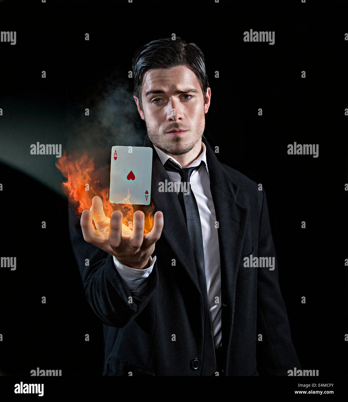 Magician produces an ace in flames Stock Photo