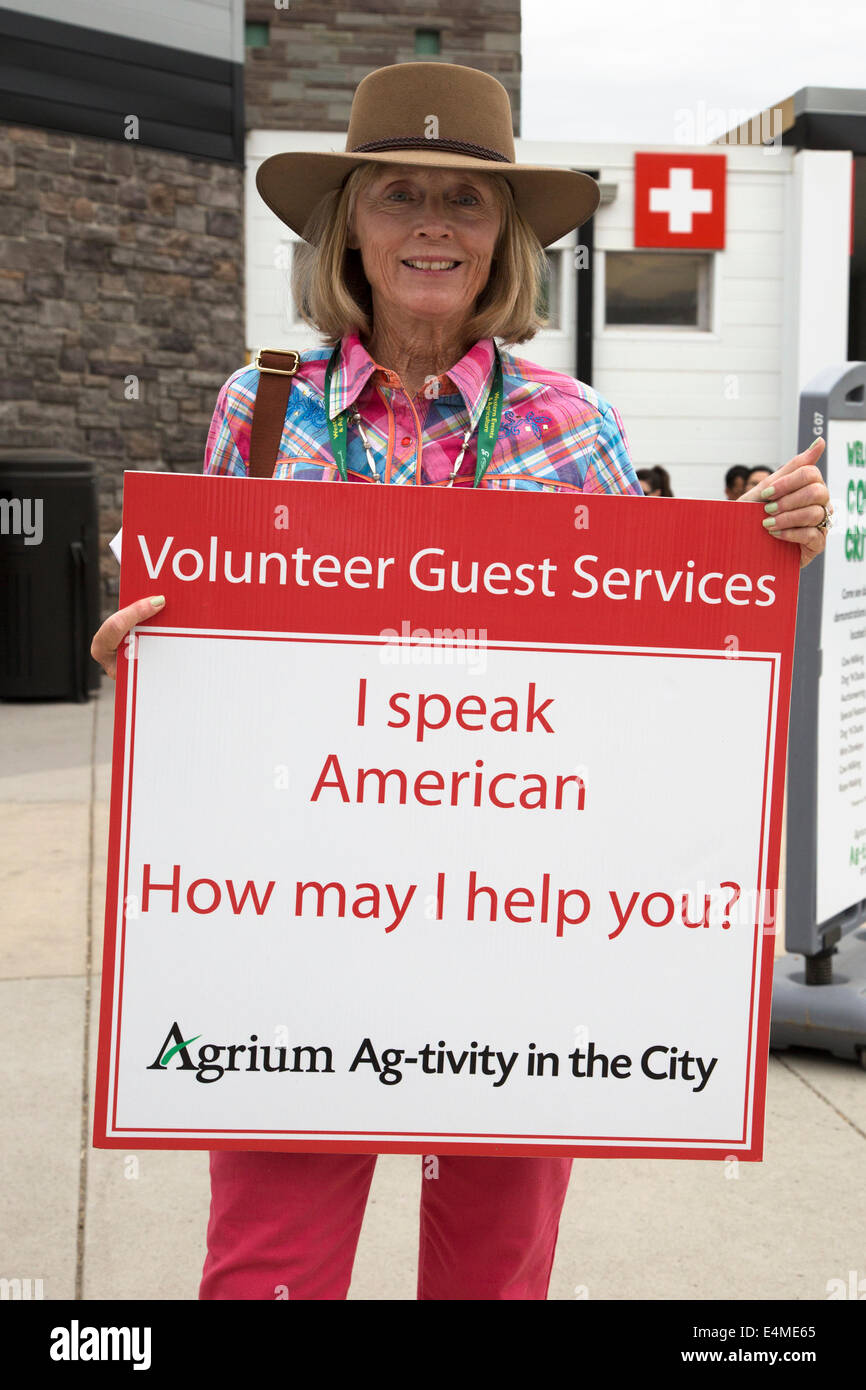 Woman holding volunteer guest services sign at Calgary Stampede, Canada Stock Photo