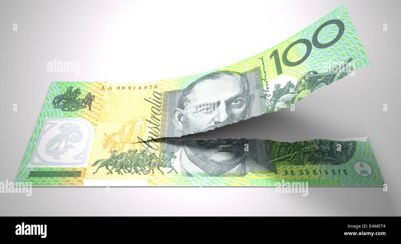 A concept picture of a regular australian one hundred dollar note tearing in two length ways on an isolated background Stock Photo