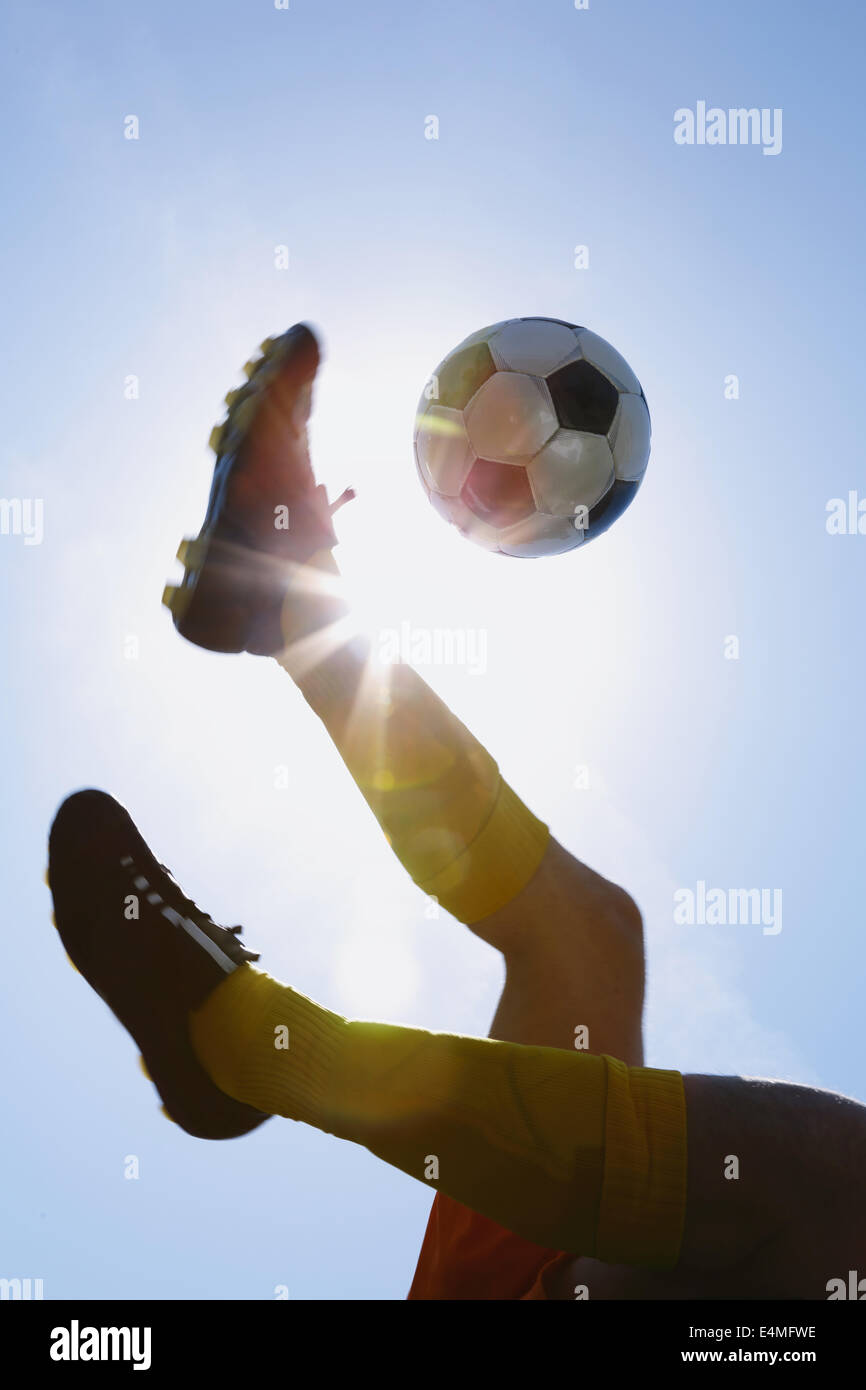 Football player kicking ball in midair Stock Photo Alamy