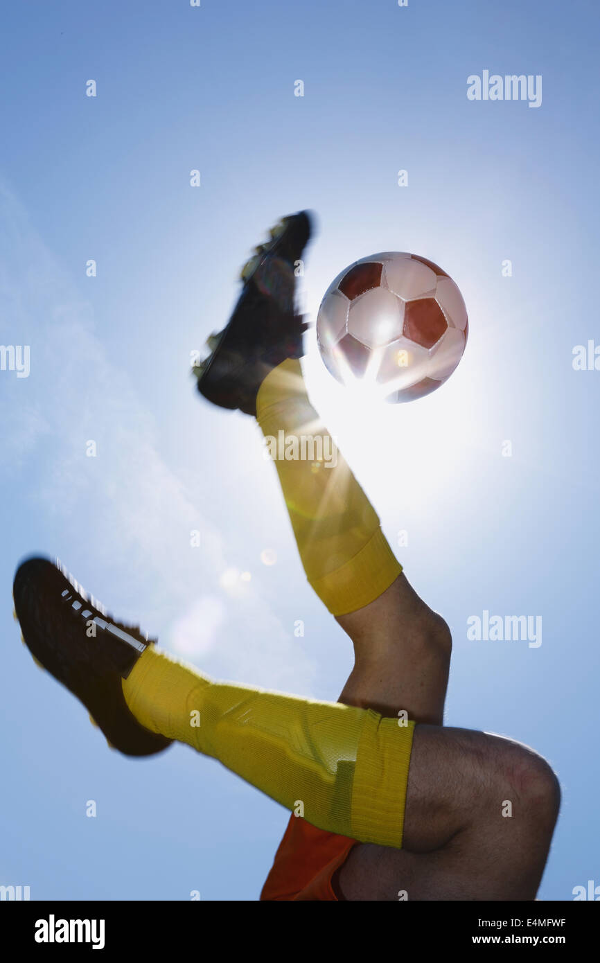 Football player kicking ball in midair Stock Photo Alamy