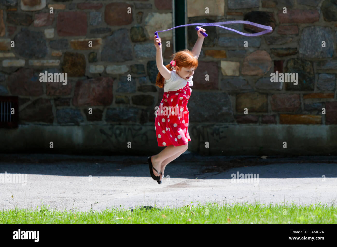 Red hair girl jumping the rope Stock Photo