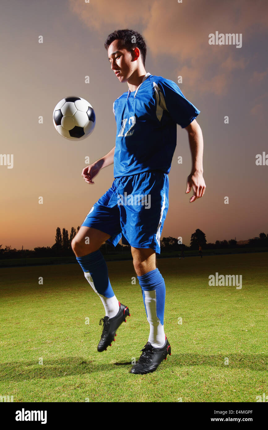 Football player in a blue uniform lifting ball Stock Photo Alamy