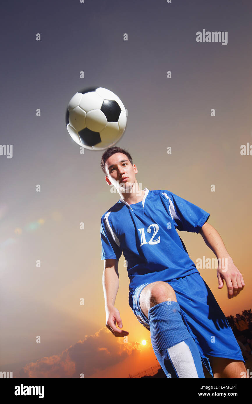 Football player in a blue uniform lifting ball Stock Photo Alamy