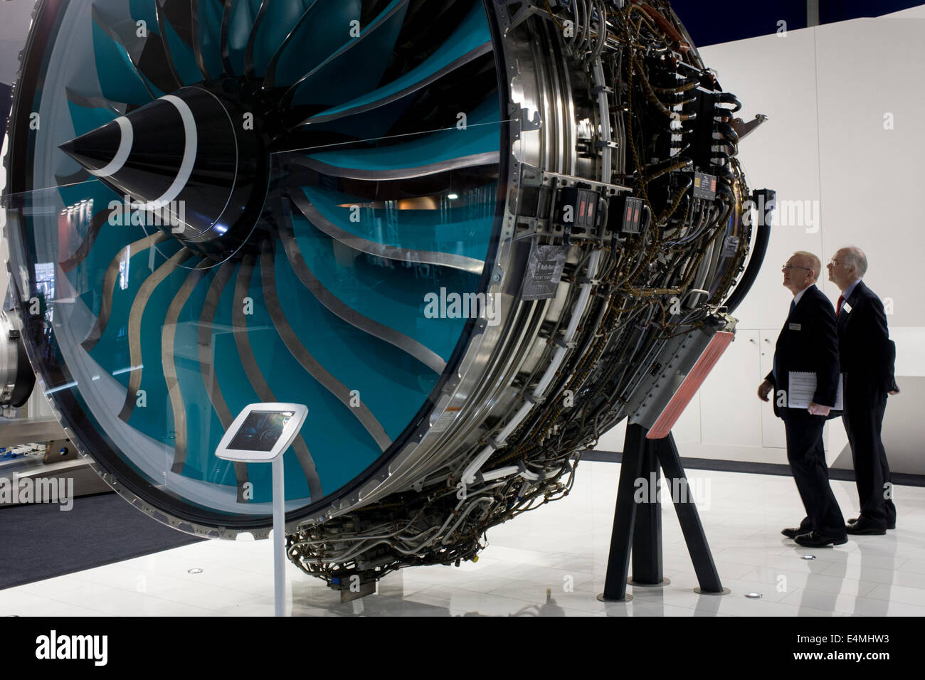 A full-size Trent jet engine is admired by delegates visiting British Rolls-Royce manufacturer's exhibition stand at the Farnborough Air Show, England. Rolls-Royce Trent is the name given to a family of three-spool, high bypass turbofan aircraft engines manufactured by Rolls-Royce plc. The engine is named after the River Trent in the Midlands of England. The civil aerospace business is a major manufacturer of aero engines for all sectors of the airliner and corporate jet market. Rolls-Royce powers more than 30 types of commercial aircraft and has almost 13,000 engines in service around  world. Stock Photo