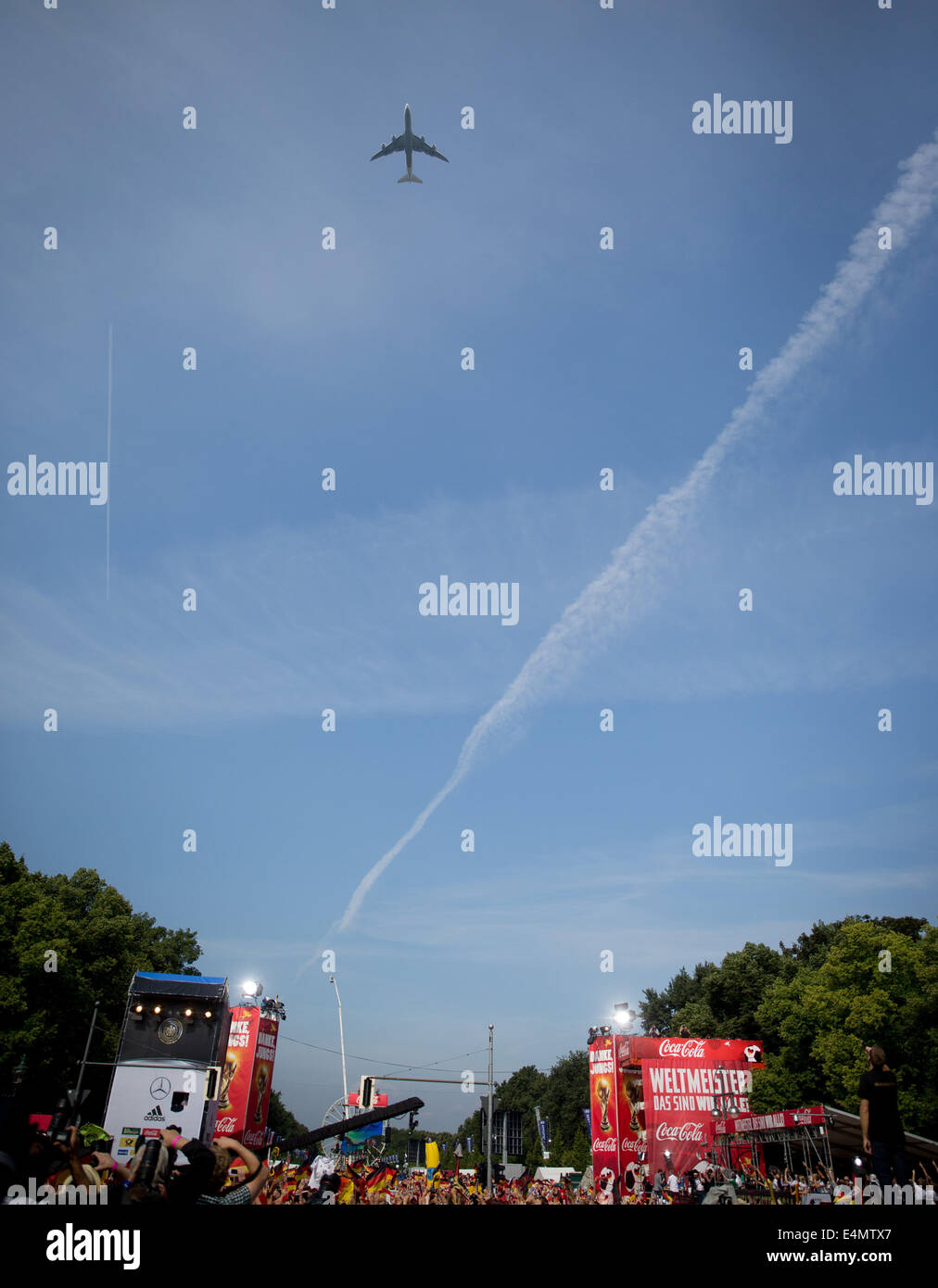 Berlin, Germany. 15th July, 2014. Fans cheer the airliner carrying the German national soccer team as it passes over the fan fest at Brandenburg Gate in Berlin, Germany, 15 July 2014.The German team on 13 July 2014 had won the Brazil 2014 FIFA Soccer World Cup final against Argentina by 1-0 to win the title for the fourth time after 1954, 1974 and 1990. /Alamy Live News Stock Photo