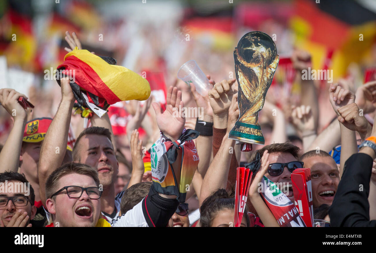 Berlin, Germany. 15th July, 2014. Fans of the German national soccer team celebrate before the reception opf the team at the fan fest at Brandenburg Gate in Berlin, Germany, 15 July 2014.The German team on 13 July 2014 had won the Brazil 2014 FIFA Soccer World Cup final against Argentina by 1-0 to win the title for the fourth time after 1954, 1974 and 1990. /Alamy Live News Stock Photo