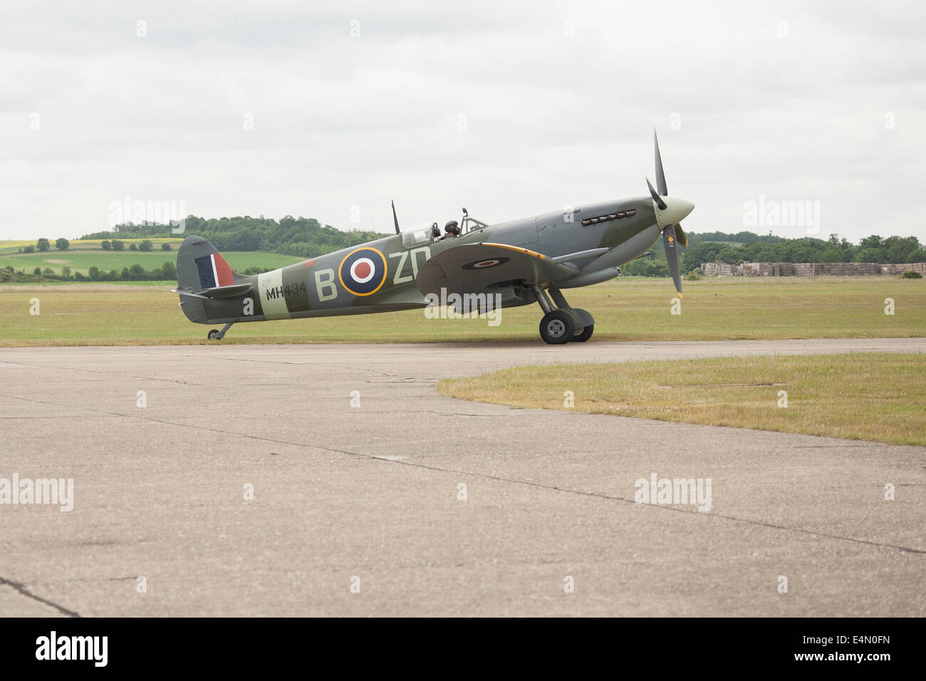 Working Supermarine Spitfire and pilot on the edge of the runway at the Imperial War Museum Duxford. Stock Photo