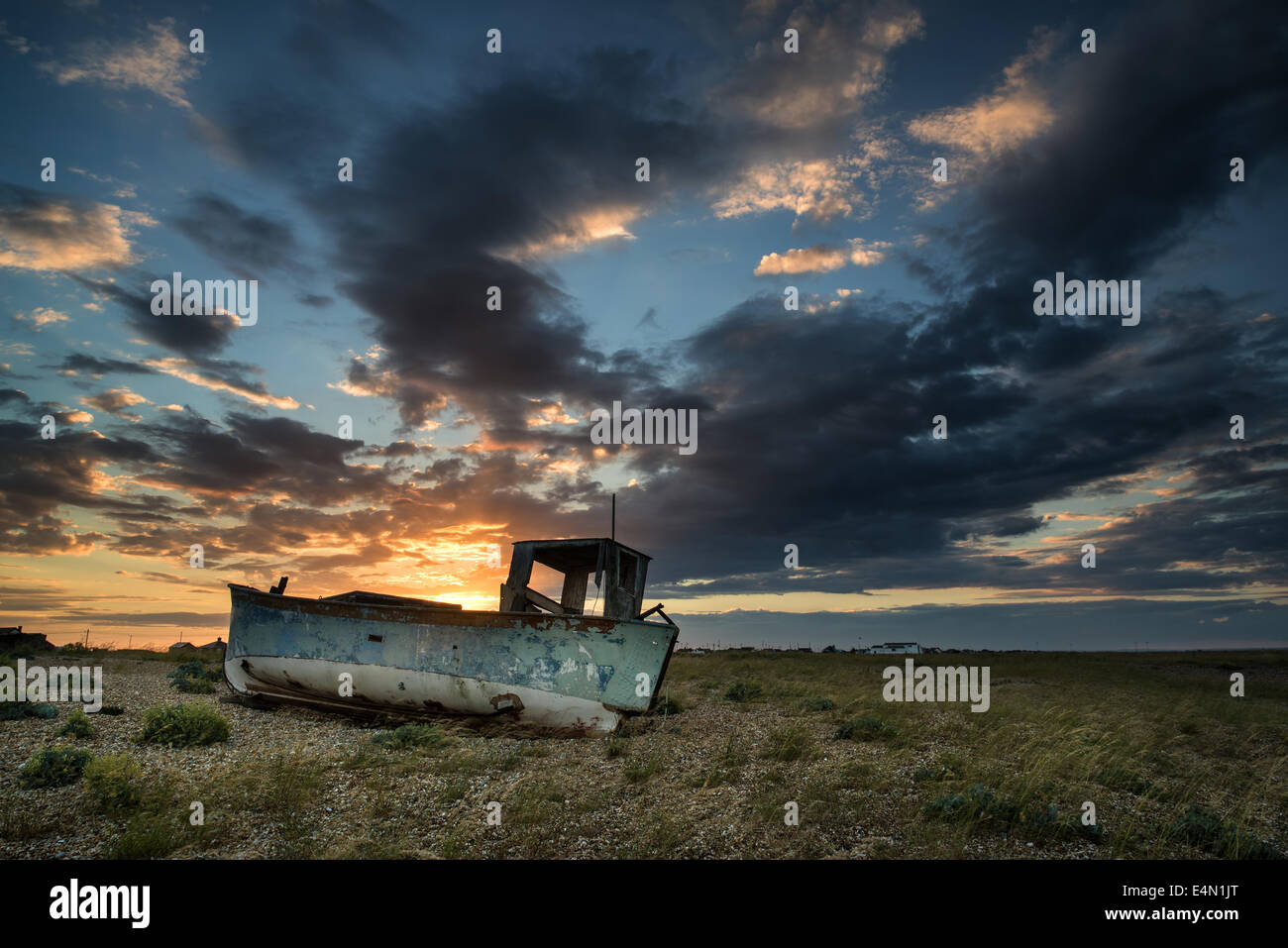 Abandoned fishing boat on shingle beach landscape at sunset Stock Photo ...