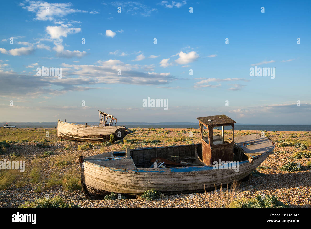 Abandoned fishing boat on shingle beach landscape at sunset Stock Photo ...