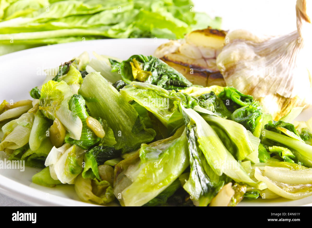 baked Romaine lettuce with garlic and pine cores Stock Photo - Alamy