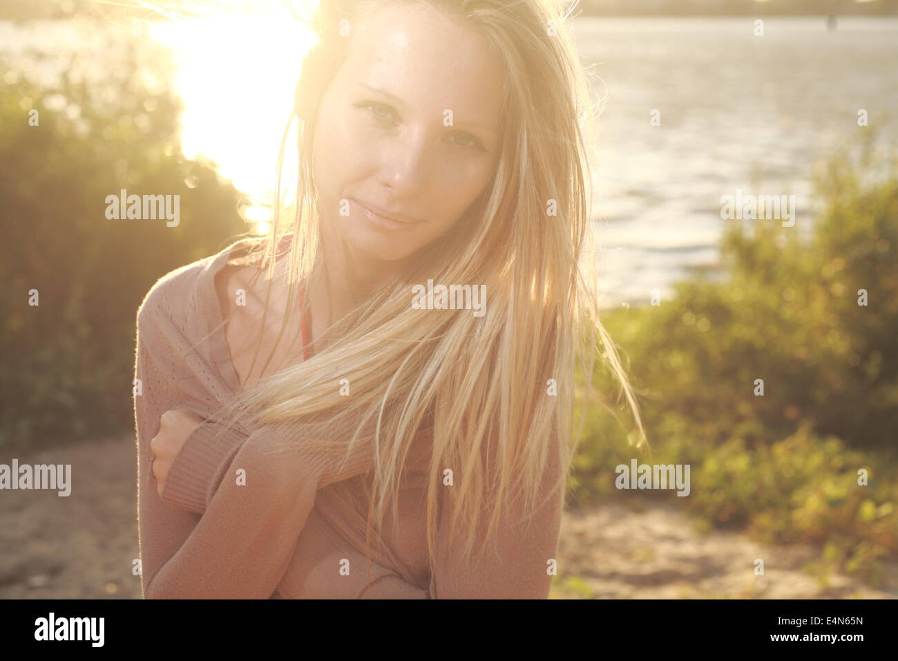 girl sitting near river against sun Stock Photo - Alamy