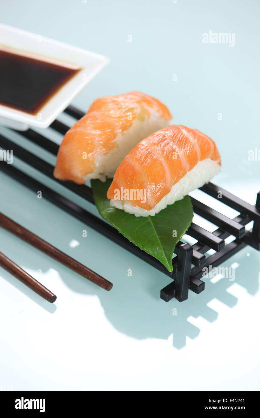 Raw salmon sat on ball of boiled rice Stock Photo