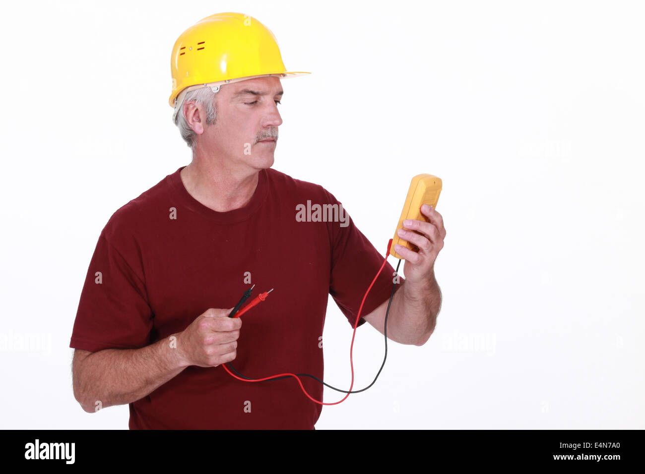 Tradesman looking at his multimeter's display Stock Photo - Alamy
