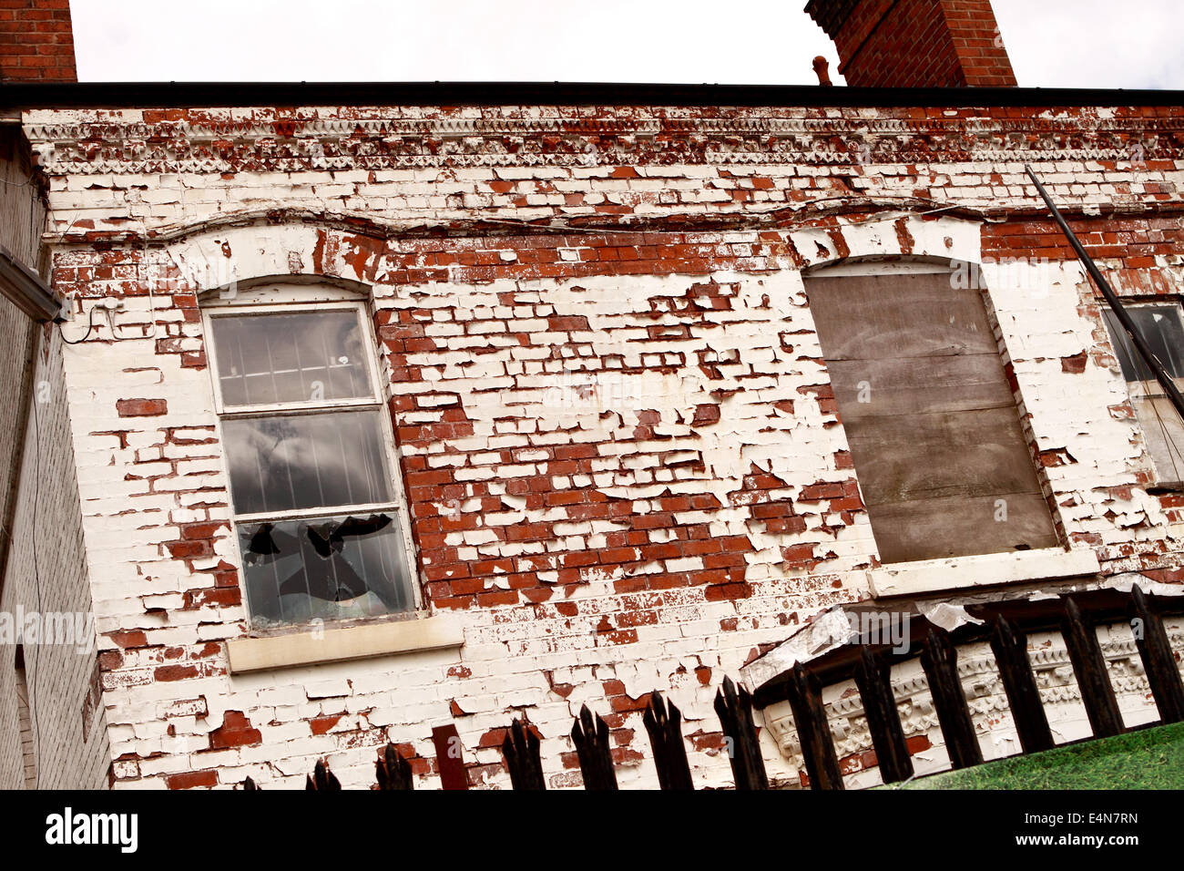 Derelict building boarded up with broken windows and peeling paint in Birmingham England UK Stock Photo