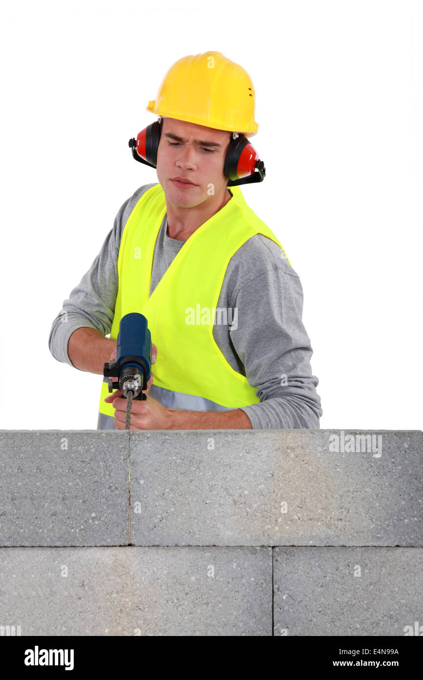 Builder using a masonry drill Stock Photo Alamy