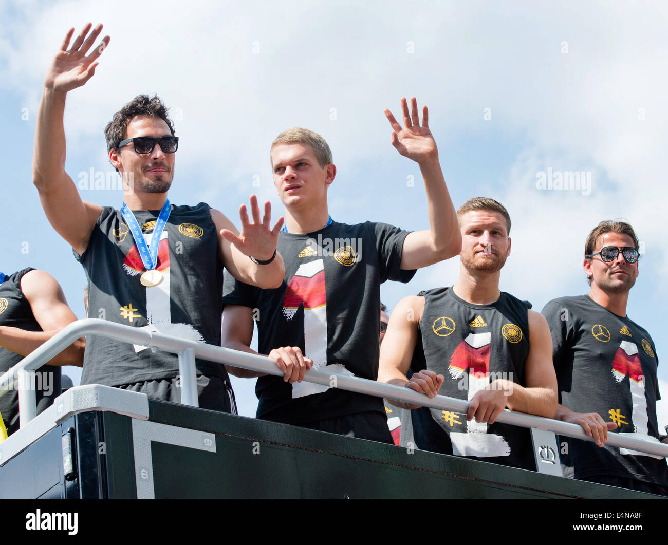 Berlin, Germany. 15th July, 2014. German national soccer players Mats Hummels (L-R), Matthias Ginter, Shkodran Mustafi and Roman Weidenfeller celebrate during their drive to Brandenburg Gate in Berlin, Germany, 15 July 2014. The German team on 13 July 2014 had won the Brazil 2014 FIFA Soccer World Cup final against Argentina by 1-0 to win the title for the fourth time after 1954, 1974 and 1990. Photo: Bernd von Jutrczenka/dpa/Alamy Live News Stock Photo