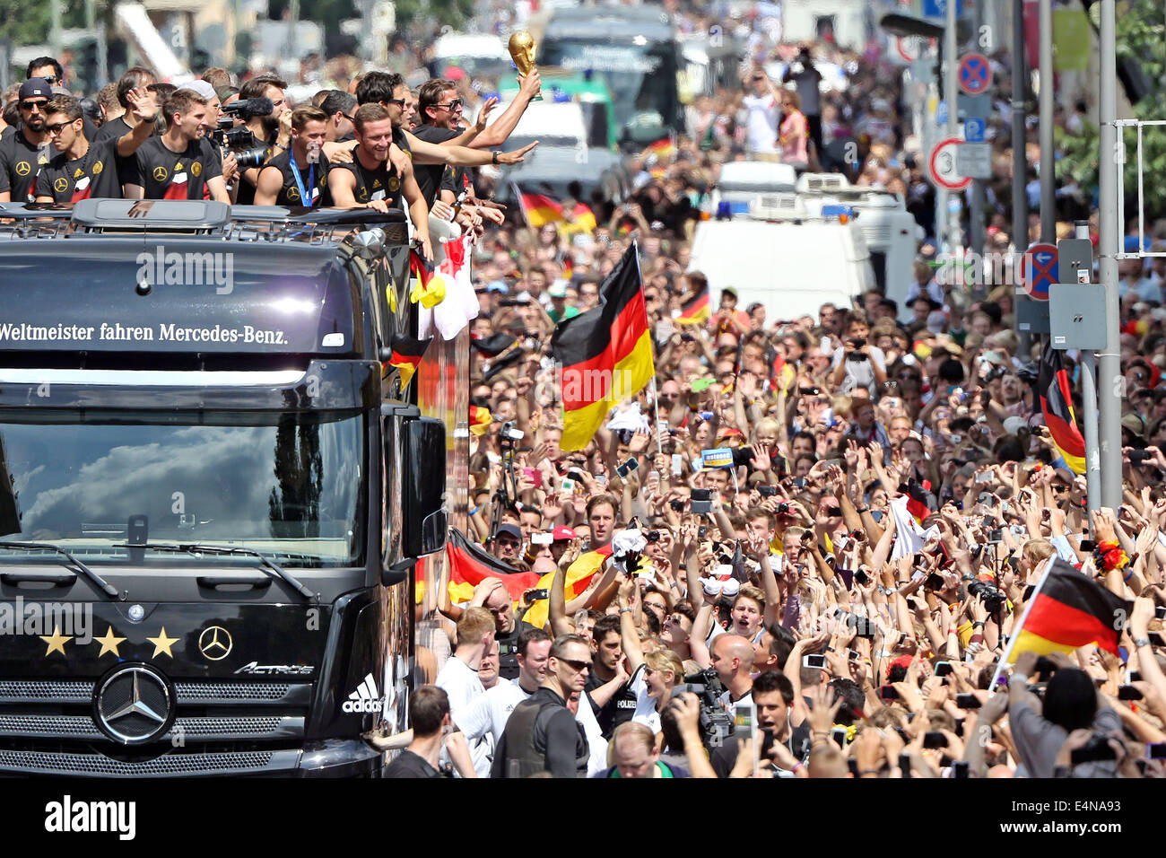 Berlin, Germany. 15th July, 2014. The German national soccer team is celebrated by fans during their drive to Brandenburg Gate in Berlin, Germany, 15 July 2014. The German team on 13 July 2014 had won the Brazil 2014 FIFA Soccer World Cup final against Argentina by 1-0 to win the title for the fourth time after 1954, 1974 and 1990. Photo: JAN WOITAS/DPA/Alamy Live News Stock Photo