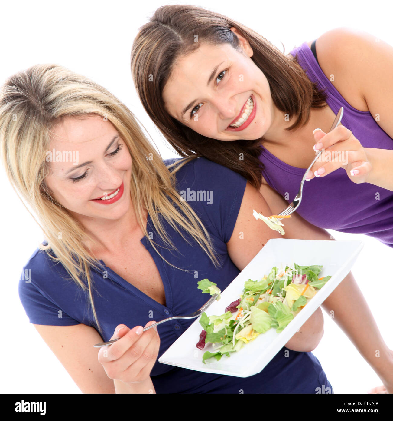 Female friends sharing a plate of salad Stock Photo