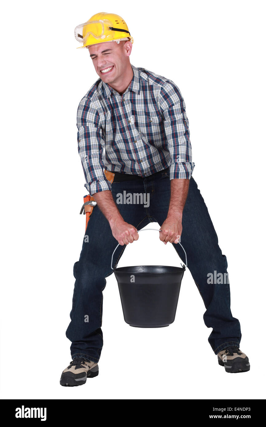 craftsman carrying a very heavy bucket Stock Photo Alamy