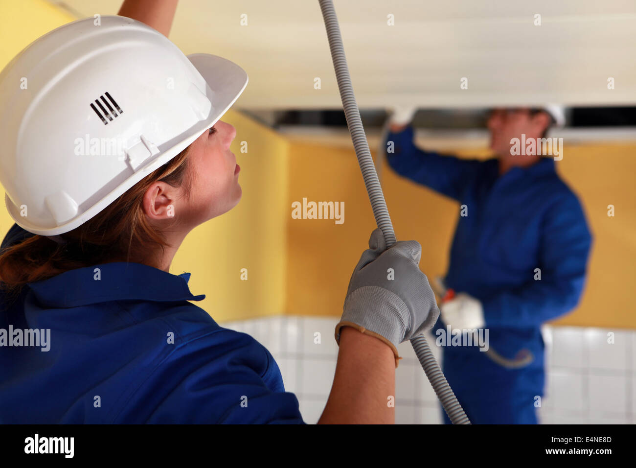 Electricians wiring a large room Stock Photo