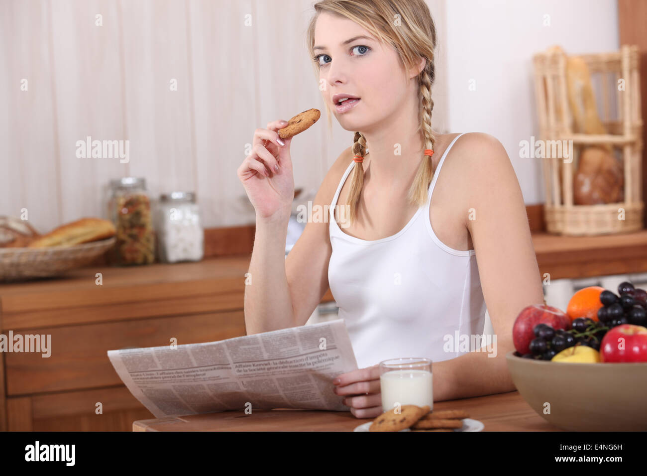Woman eating breakfast and reading newspaper Stock Photo Alamy