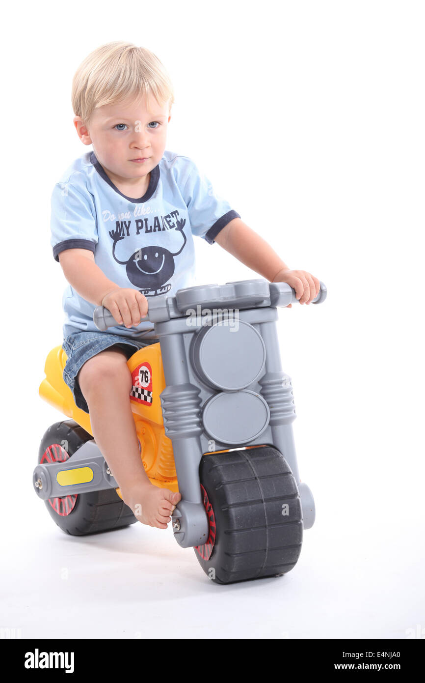 little boy on a toy motorcycle Stock Photo