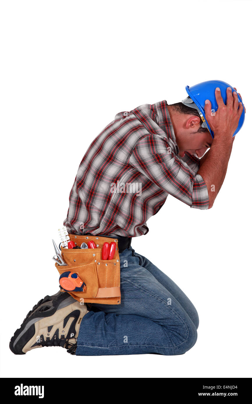 furious craftsman on his knees Stock Photo