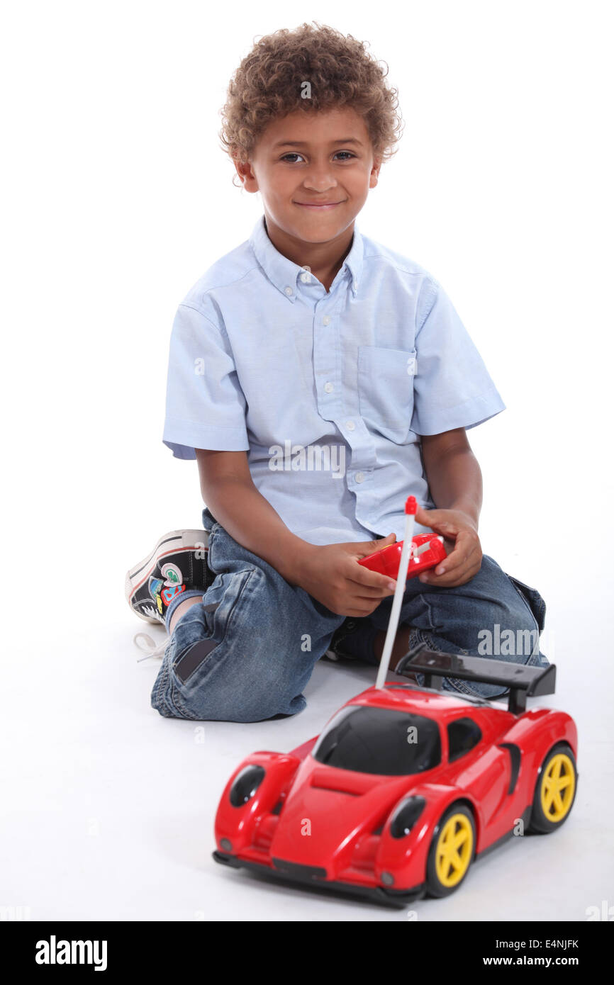 a boy playing with a radio control car Stock Photo