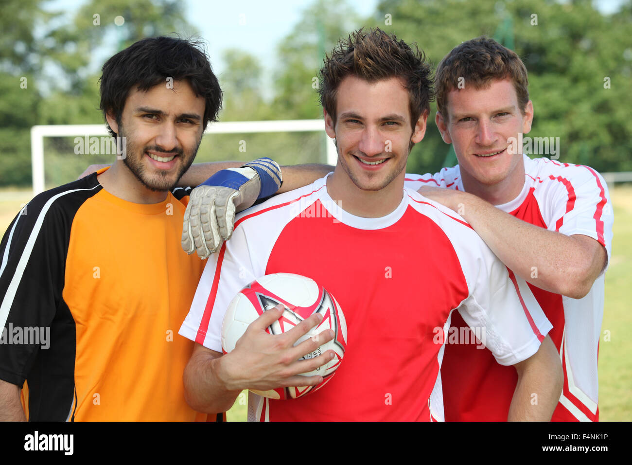 Three footballers in front of goal Stock Photo